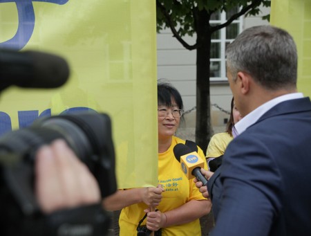 波兰知名电视台TVN记者在总统府外采访了两位法轮功学员并在当天新闻节目中播出。(黄诃欧/大纪元)